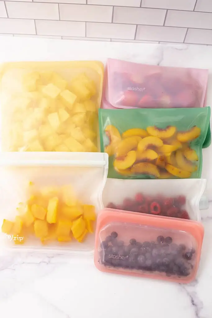Frozen berries, bananas, peaches and pineapple in freezer safe bags.
