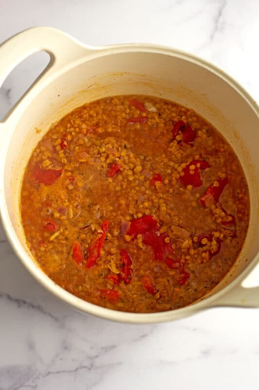 Cooked red lentils and peppers in a large pot.