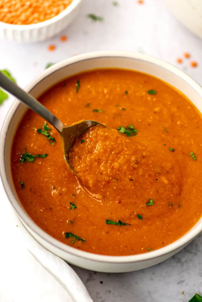 Spoon in a large bowl of sweet potato lentil soup.