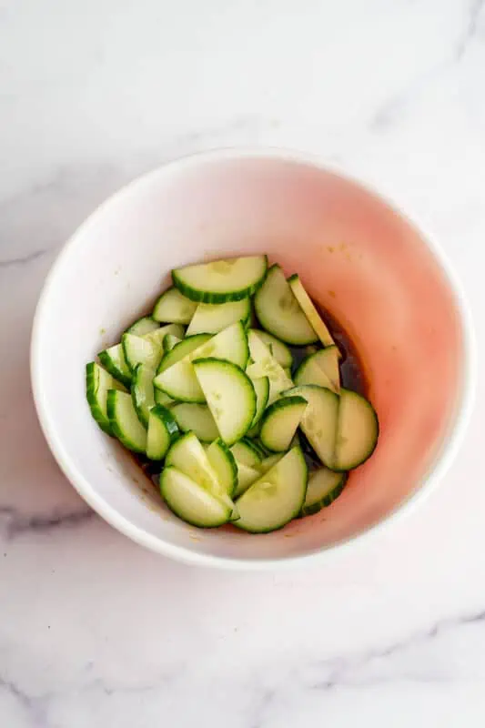 Sliced cucumber in a bowl before marinating.