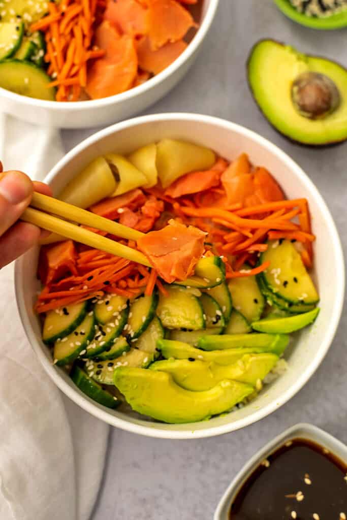 Smoked salmon being picked up by chopsticks.