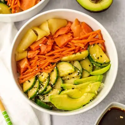 Smoked salmon sushi bowl with a white napkin on the side.