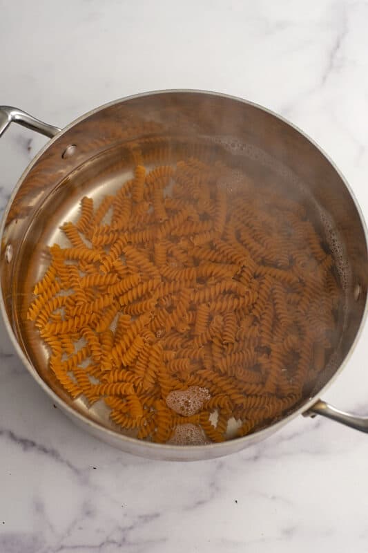 Pasta added to pot of boiling water.