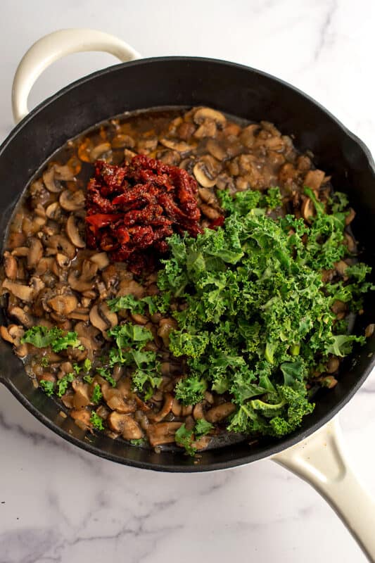 Sundried tomato and shredded kale added to skillet with mushrooms.