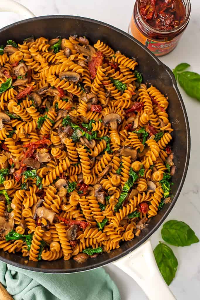 Mushroom sundried tomato pasta in a skillet with sundried tomato on the side.