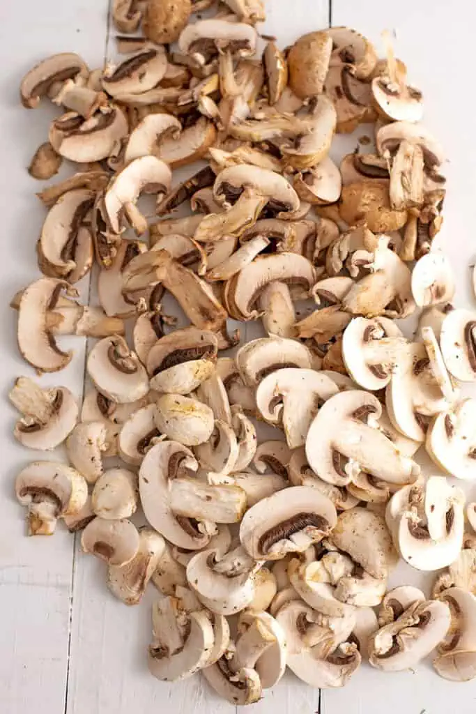 Sliced mushrooms on a white countertop. 