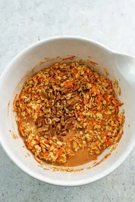 Chopped pecans added to bowl with carrot cake oatmeal mixture.
