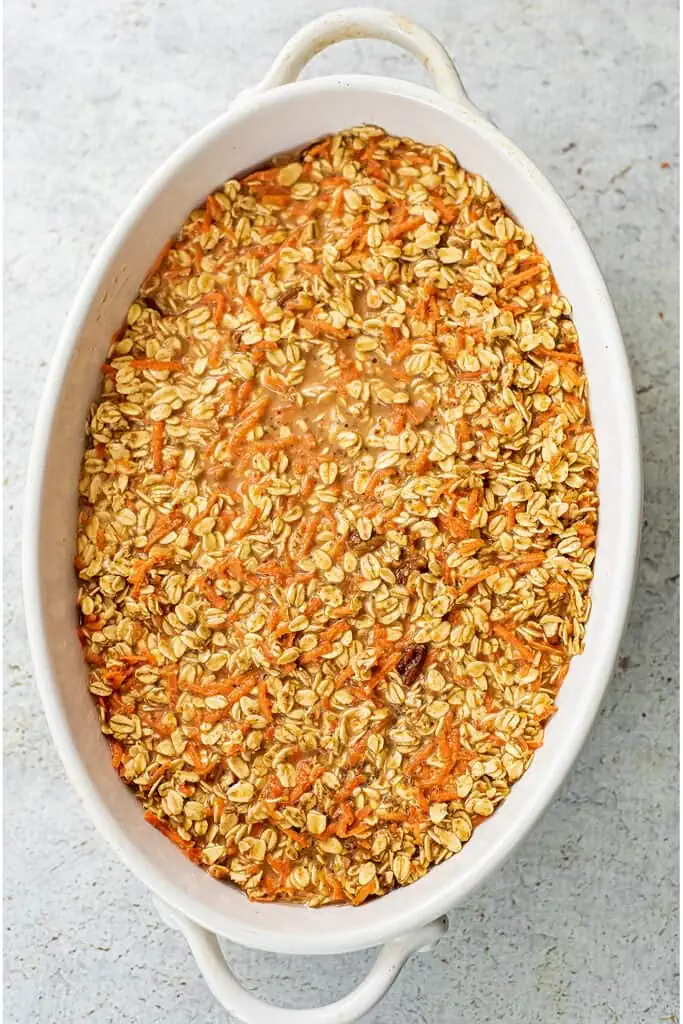 Carrot cake oatmeal mixture added to large oval casserole dish.