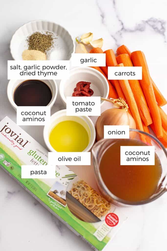 Ingredients to make carrot pasta sauce on marble countertop. 