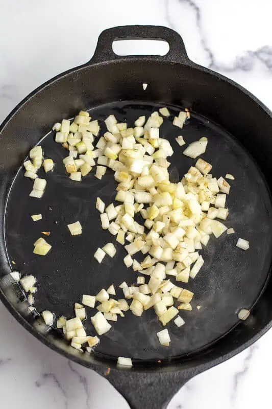 Chopped onion in a cast iron skillet.