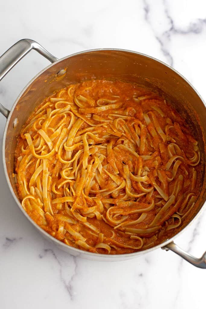 Pasta with carrot sauce in a large pot.