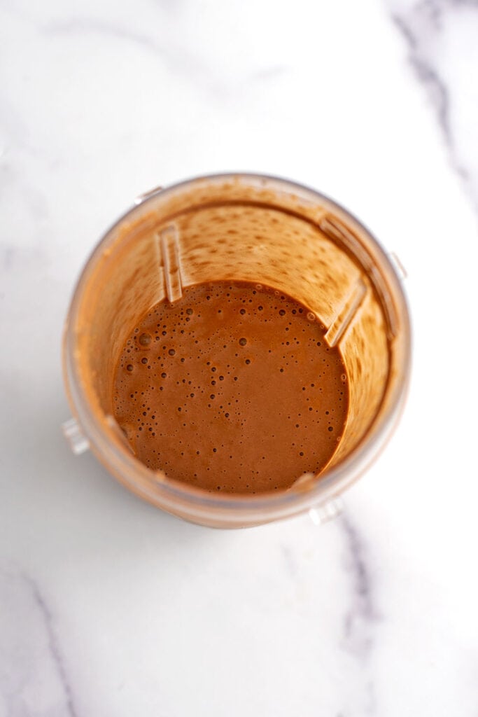 Chocolate banana oat smoothie in a blender cup after being blended.