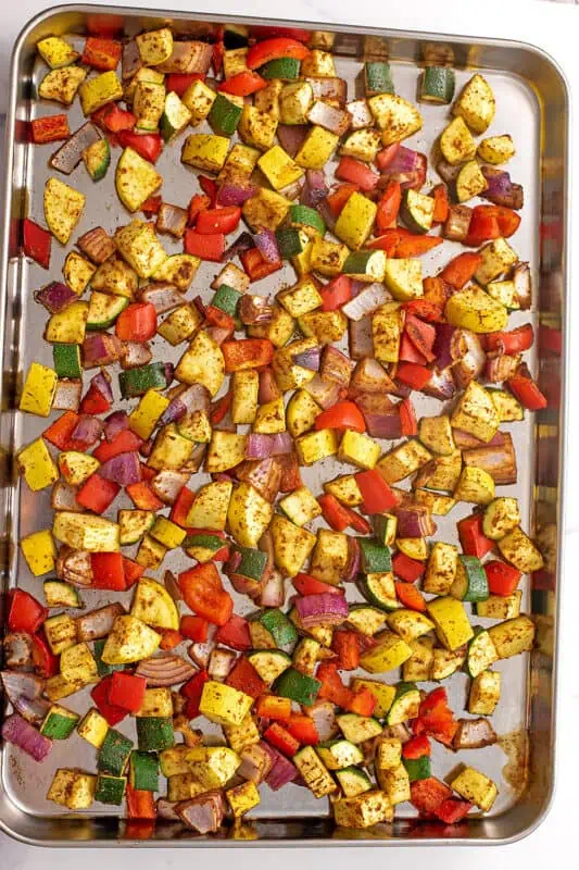 Sheet pan full of Mexican veggies before roasting.