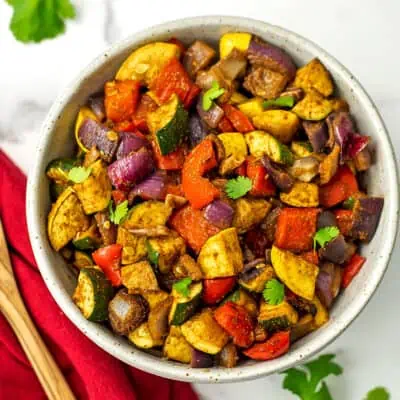 Mexican roasted vegetables in a large white bowl, napkin on the side.