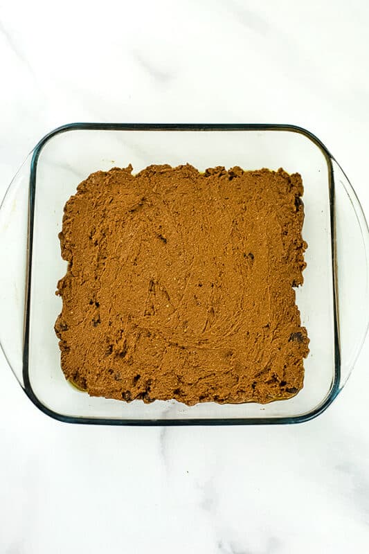 Protein pumpkin brownie mixture in glass baking dish before baking.