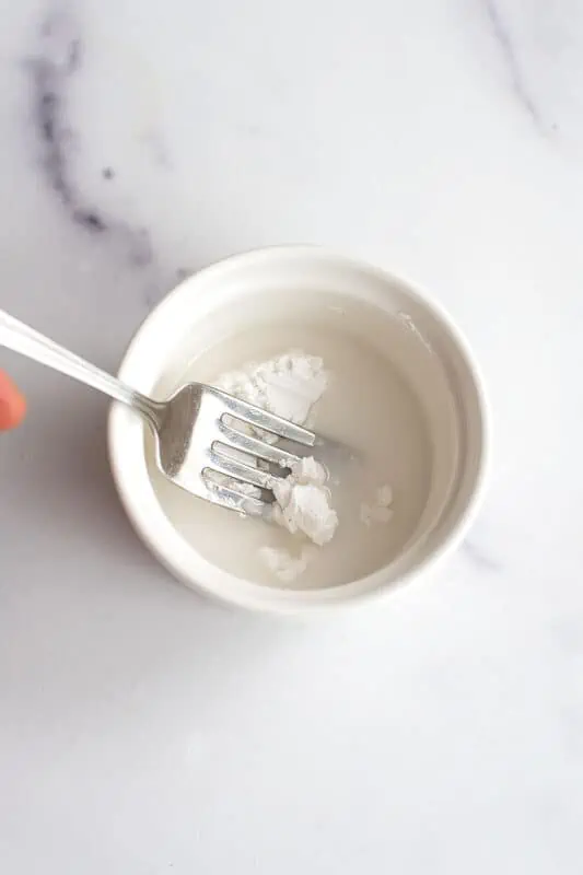 Arrowroot powder and water in a white ramekin.