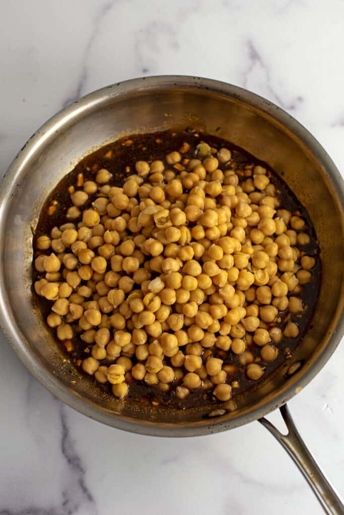 Drained chickpeas added to the skillet with teriyaki sauce.