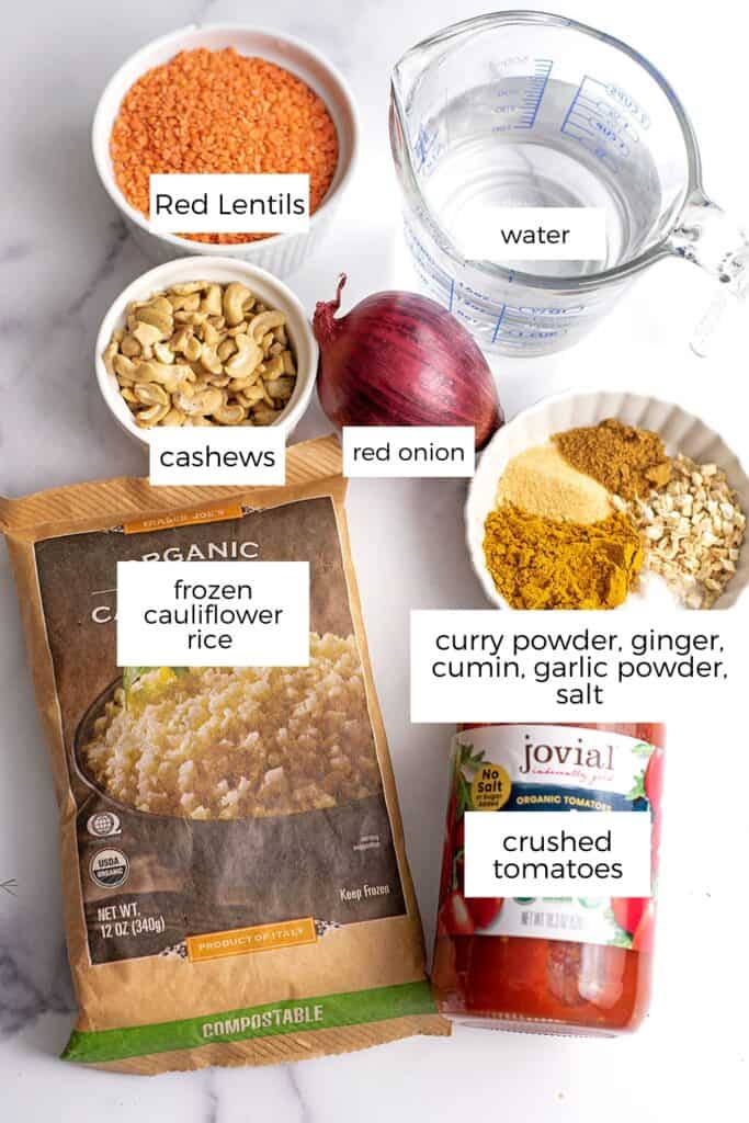 Ingredients to make vegan red lentil curry on a marble countertop. 