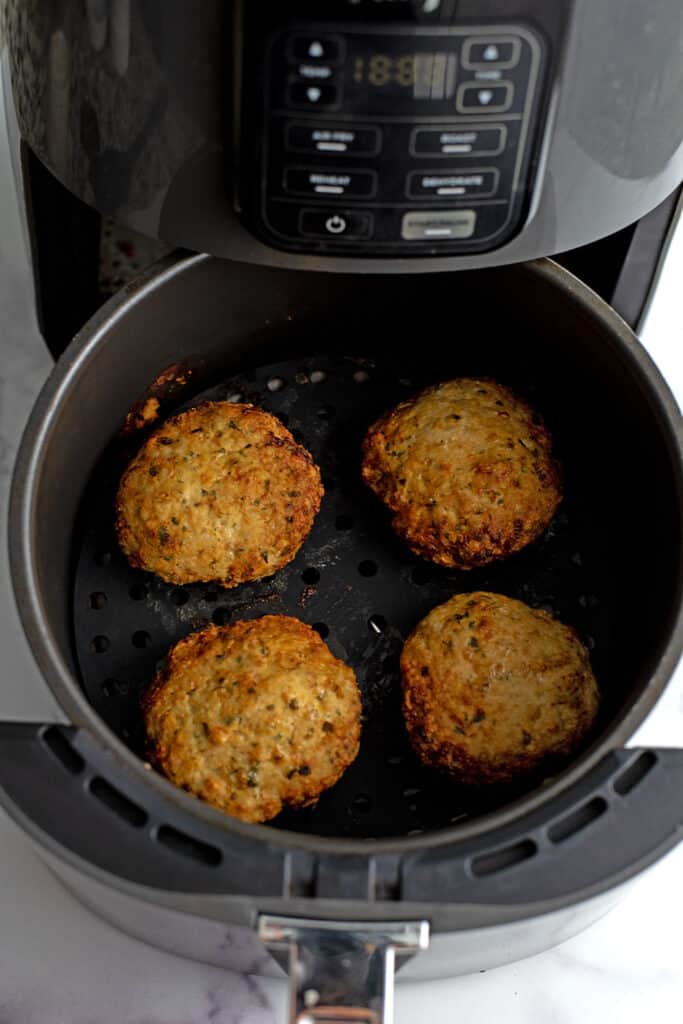 Chicken burgers in air fryer before flipping.