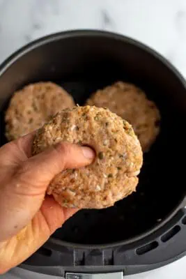 Thumb pressing down the center of chicken patty.