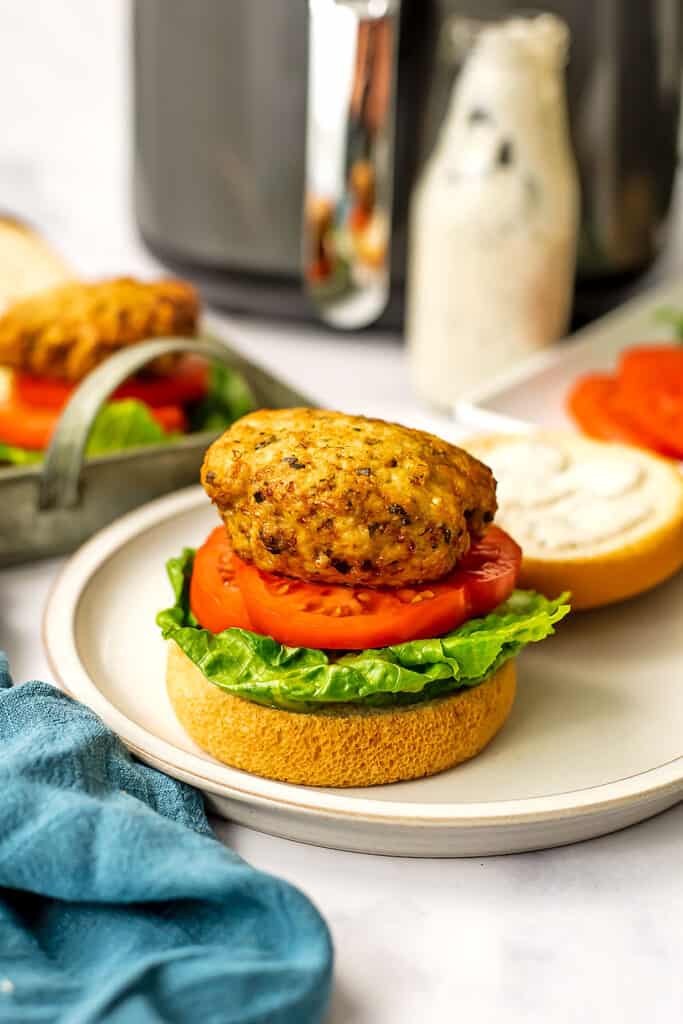 Air fryer chicken patty burger on a bun with ranch dressing in background.