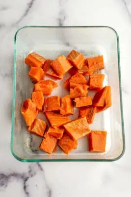 Salmon cubes in glass container.