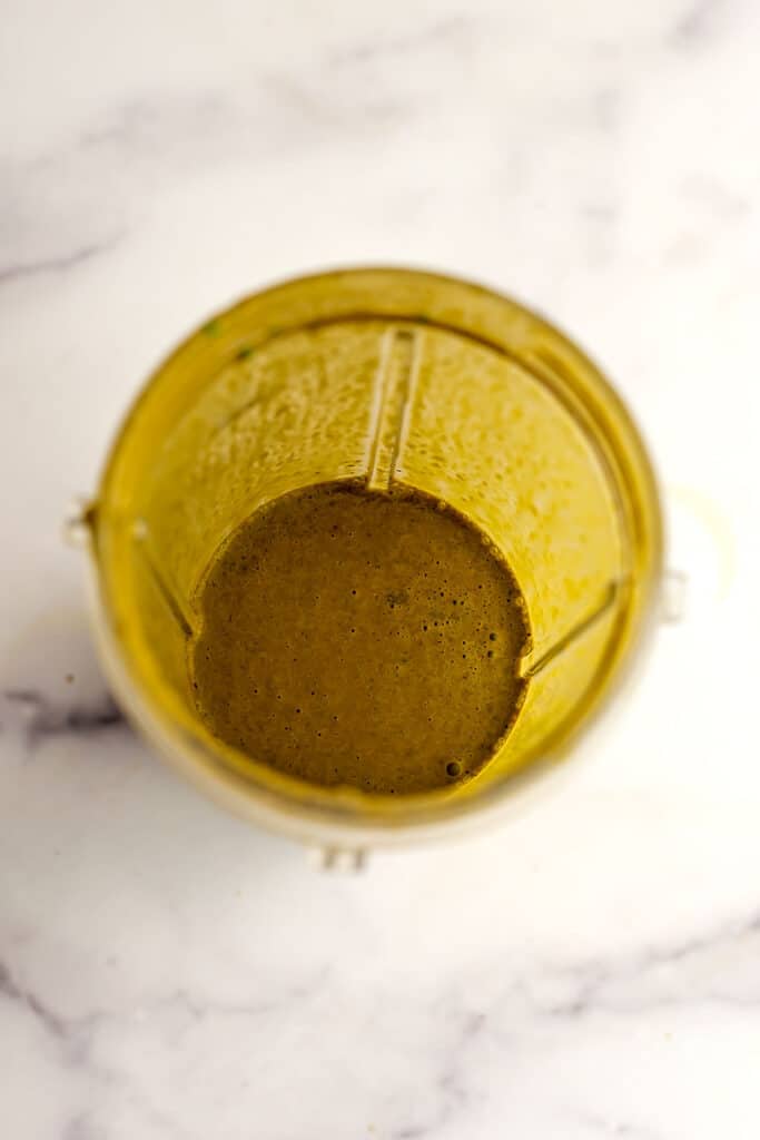 Basil balsamic vinaigrette in blender cup after blending.