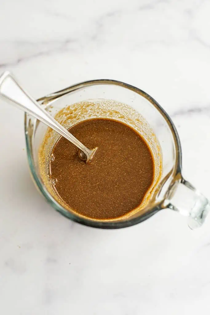 Balsamic tahini dressing in a glass measuring cup.