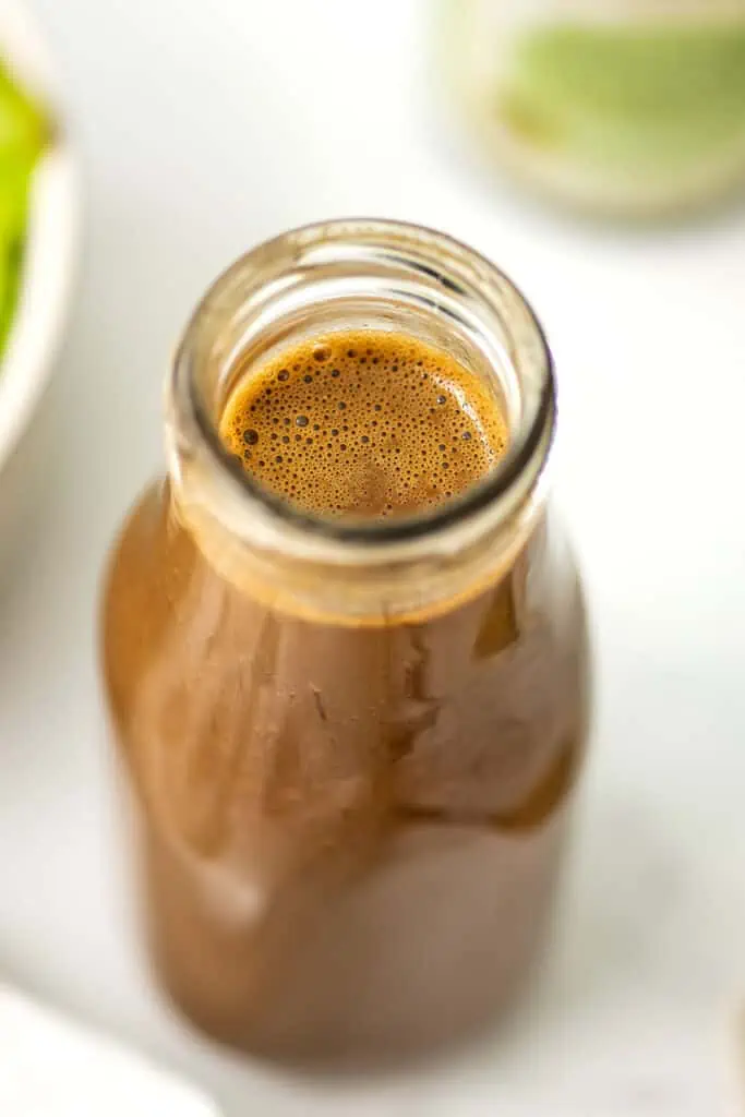 Glass bottle filled with balsamic tahini dressing.
