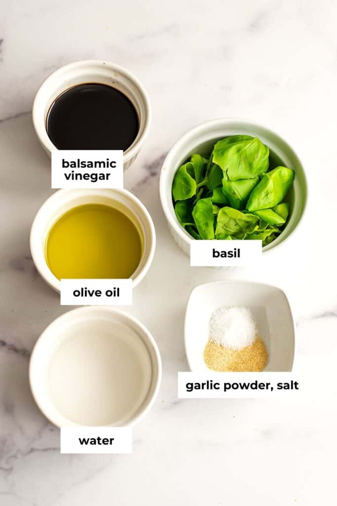 Ingredients to make basil balsamic vinaigrette in ramekins.