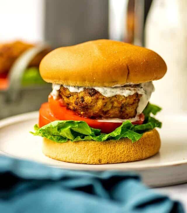 Air fryer chicken burger on a bun with ranch dressing, lettuce and tomato.