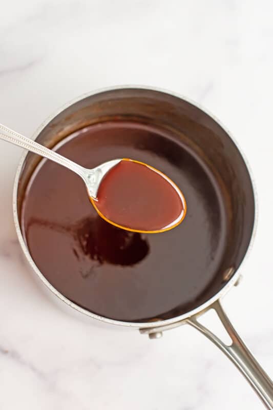 Thickened honey sriracha sauce in a small pot after cooking.