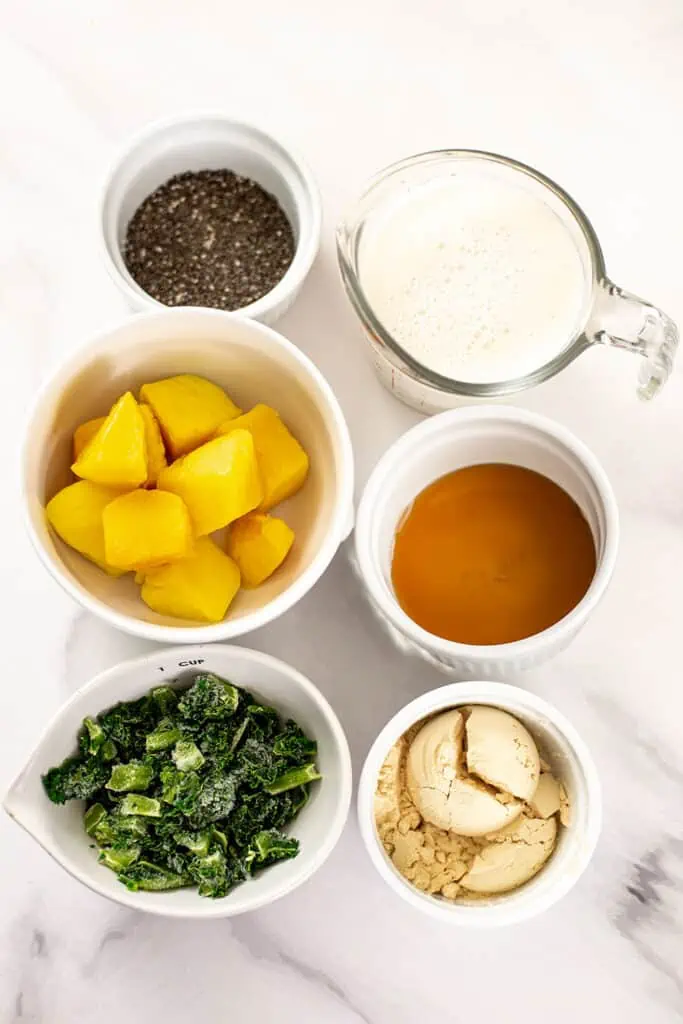 Ingredients to make mango kale smoothies in ramekins.