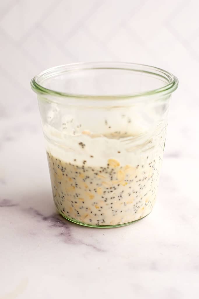 Yogurt, oats and chia seeds in a glass jar.