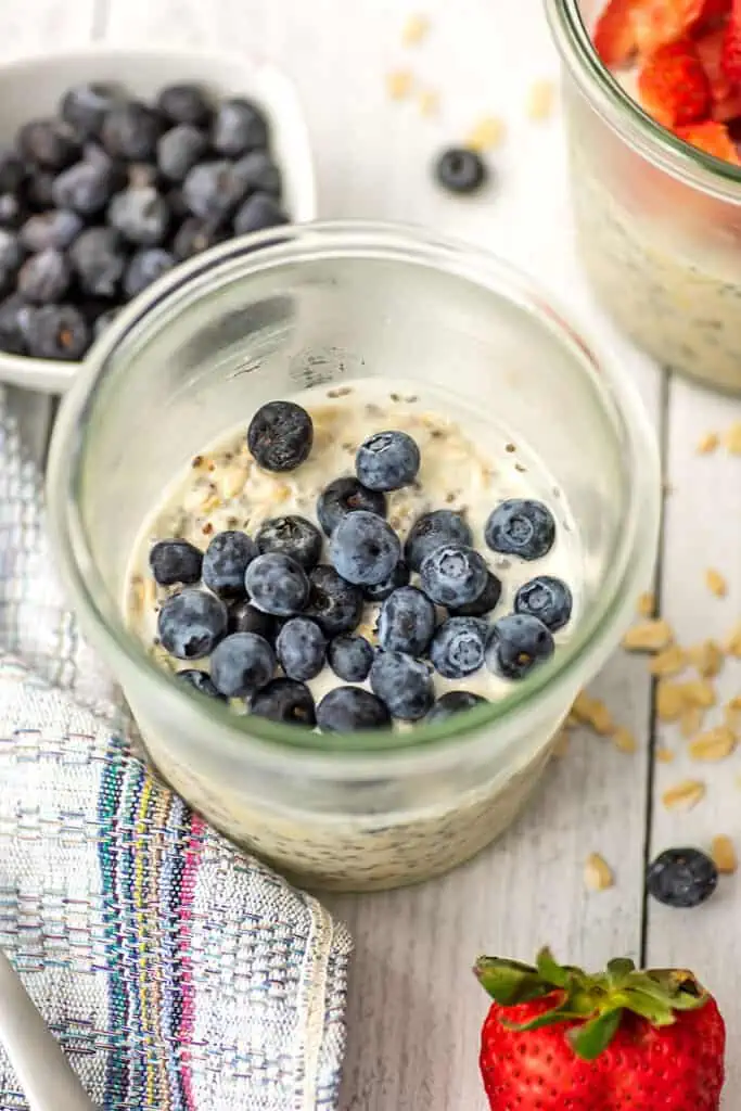 Glass jar of overnight oats with blueberries.
