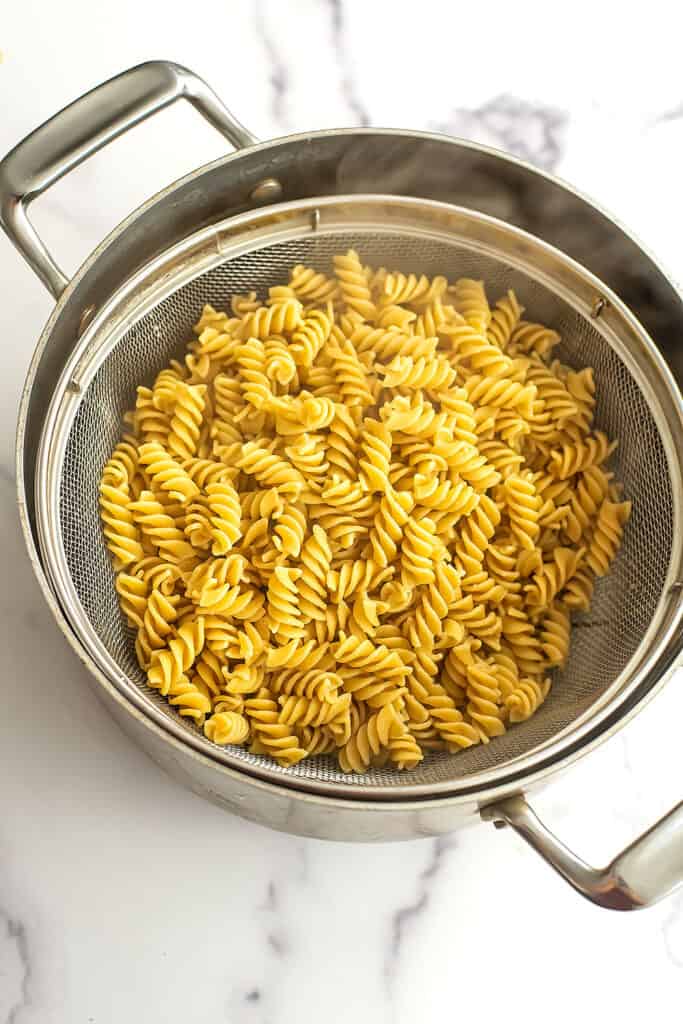 Cooked pasta in a mesh strainer.