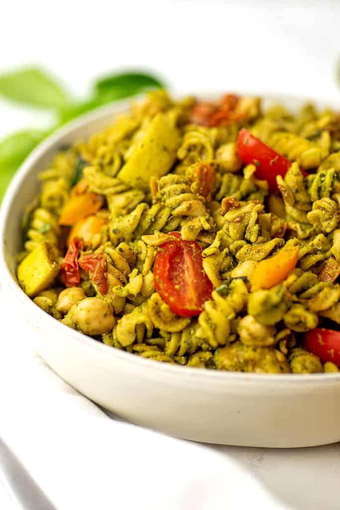 Large bowl filled with pesto vegetable pasta.