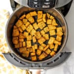 Crispy dairy free croutons in an air fryer basket.