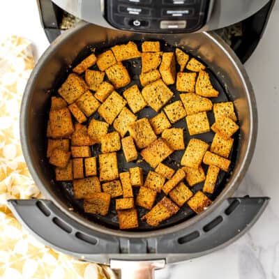 Crispy dairy free croutons in an air fryer basket.
