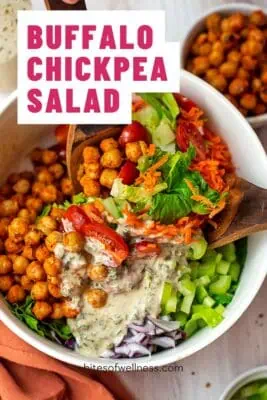 Large bowl of buffalo chickpea salad with wood spoon in the bowl.