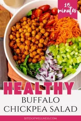 Large bowl of buffalo chickpea salad with wood spoon in the bowl.