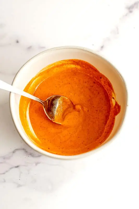 Buffalo tuna salad sauce ingredients combined and stirred in a bowl.