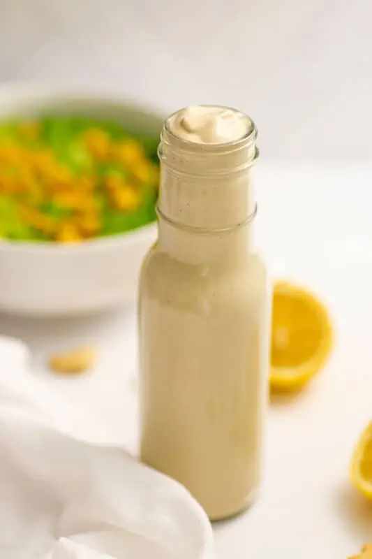 Oil free caesar dressing in a bottle with lemon in background.