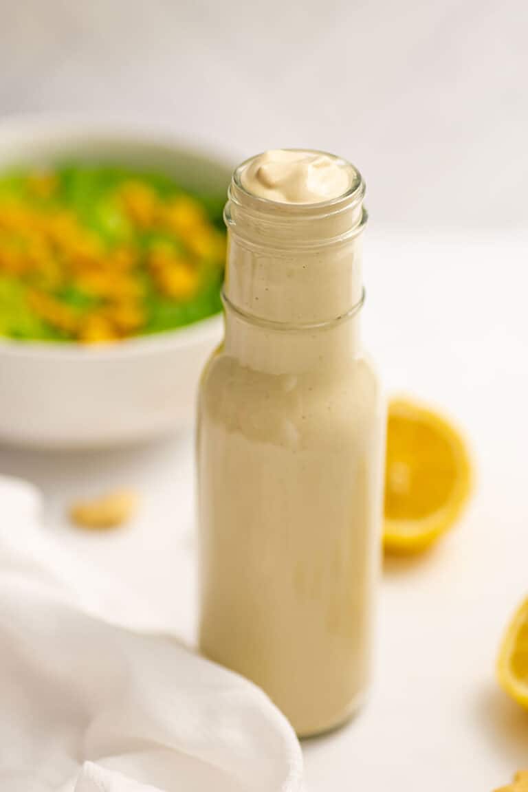 Oil free caesar dressing in a bottle with lemon in background.