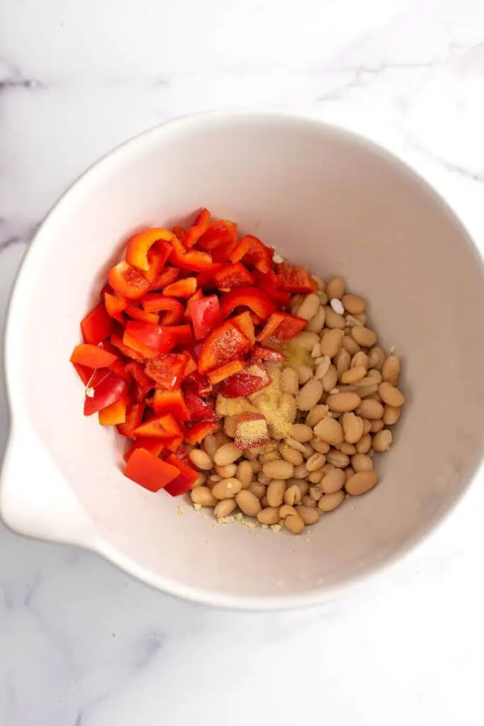White beans and red bell peppers in a bowl.