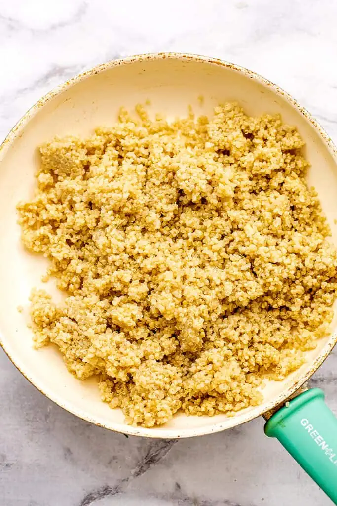 Quinoa in a skillet being warmed up.