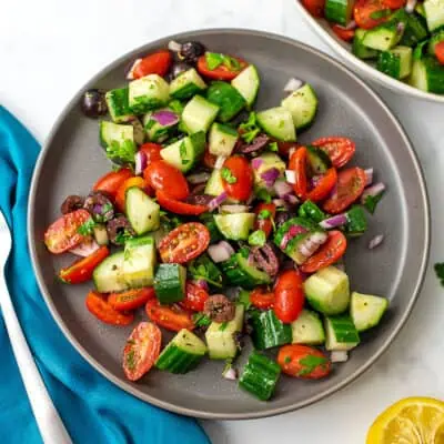 Mediterranean cucumber tomato salad on a gray plate.