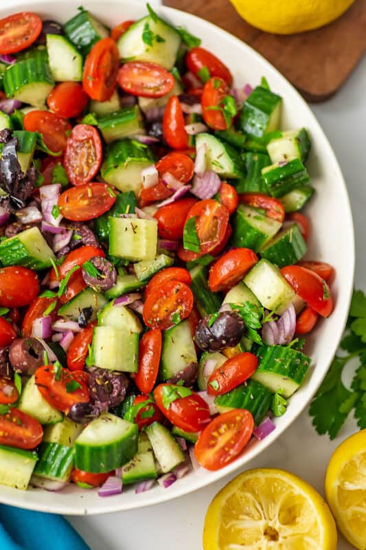 Mediterranean tomato cucumber salad on a white plate.