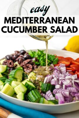Mediterranean tomato cucumber salad getting lemon vinaigrette dressing poured on it.