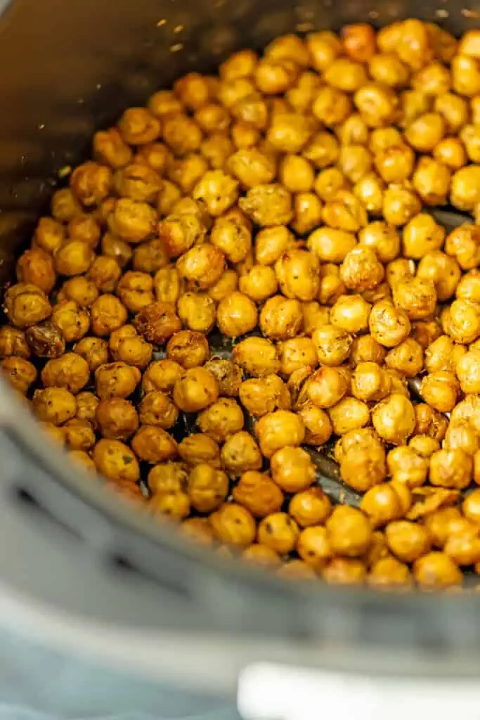 A close up image of air fryer chickpeas in an air fryer.